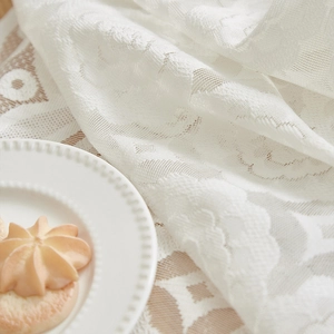 Elegant white lace tablecloth with floral patterns and a luxury vintage tea party aesthetic