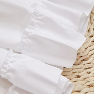 Detail of white phantom yarn tier curtain featuring layered ruffles and textured fabric