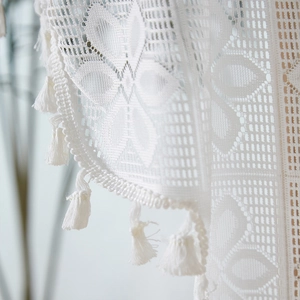 White French lace door curtain with intricate crochet patterns and decorative fringe tassel