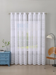 Detail of white lace curtains with damascus pattern and metal grommet top hanging