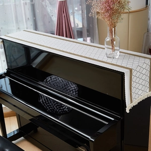 Linen piano cover with black grid pattern, gold lace trim and elegant white tassels