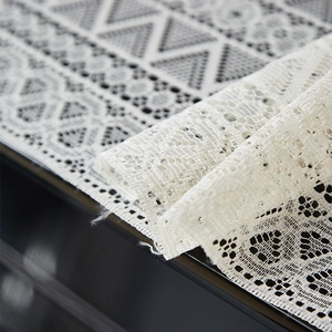 Macro shot of elegant white lace piano cover with intricate floral and geometric patterns