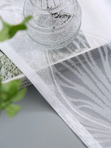 Detail der weißen Feder-Gardine aus Netzstoff mit feiner Textur in gemütlicher Atmosphäre