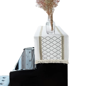 Elegant white linen piano cover runner with black diamond pattern and gold trim tassels