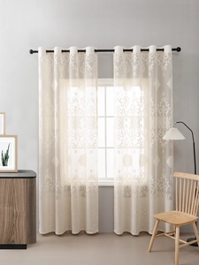 Detail of beige sheer curtains featuring elegant damask patterns and black metal grommets