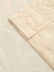 Macro detail of cream-colored lace curtain fabric with elegant floral embroidery patterns