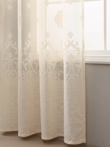Macro detail of cream jacquard sheer curtain with damask scroll and geometric pattern