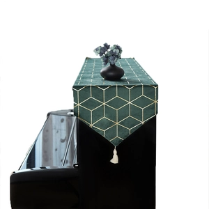 Dark green velvet piano runner with golden geometric patterns and white tassels