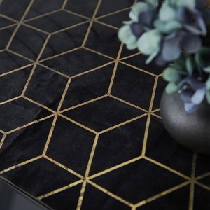 Close-up of luxury black velvet runner with gold geometric patterns and floral decor