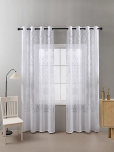Detail view of white sheer curtains featuring elegant damascus patterns with metal grommets