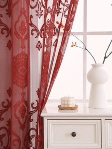 Detail of red damask embroidery on translucent tulle curtain with mesh texture