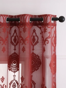 Detail of dark red semi-transparent curtain with flocked damascus pattern and silver grommets