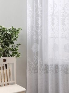 Detail of white semi-transparent lace curtain with damascus floral pattern and metal rings