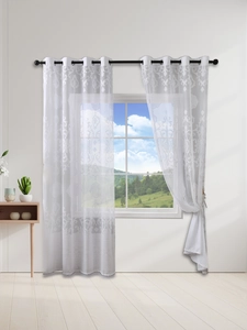 Close-up of white damascus pattern sheer curtain with black metal grommet top