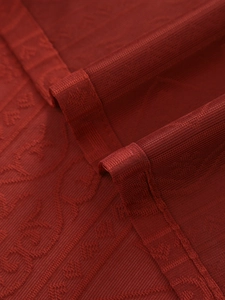 Detailed macro view of dark red lace curtain with vintage floral embroidery and mesh texture