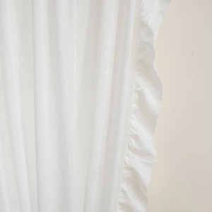 Close-up of white velvet curtain with ruffle edge detailing and soft draping effect
