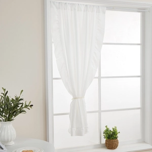 Dettaglio di tenda bianca semitrasparente con elegante bordo a balze e laccetto decorativo