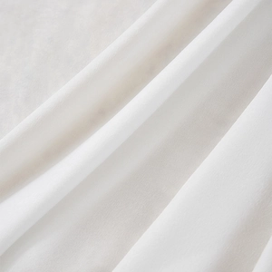 Dettaglio macro del tessuto per tende in velluto bianco con trama morbida e drappeggio