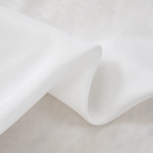 Dettaglio della tenda in velluto bianco di lusso con trama setosa e lucentezza perlata