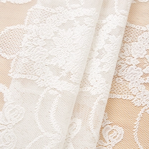 Close-up of white French vintage lace tablecloth featuring intricate floral embroidery