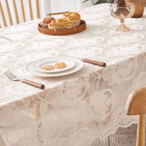 Detail of cream white lace tablecloth featuring elegant hollow floral patterns