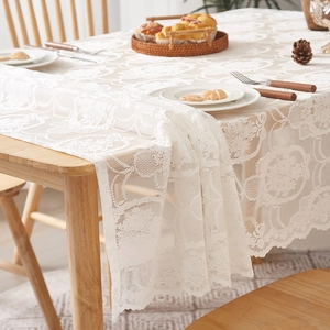 Close-up of white French vintage lace tablecloth with floral hollow patterns
