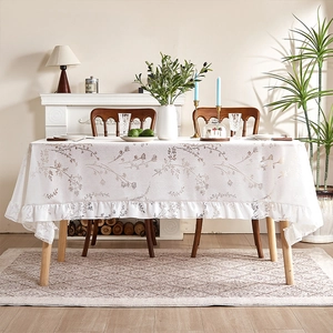 Elegant white floral tablecloth with ruffled edges for a vintage aesthetic dining room decor
