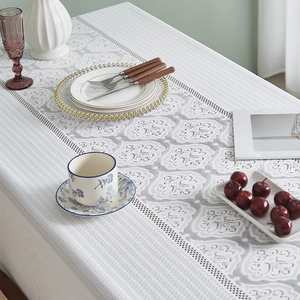 Détail de la nappe en dentelle blanche française avec motifs floraux et broderies ajourées