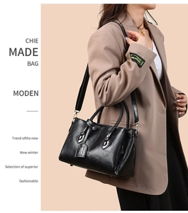 Detail of oil wax leather handbag with woven handles and detachable strap on model