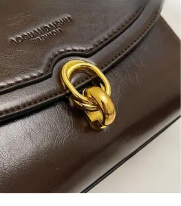 Détail du sac à main vintage marron avec fermoir doré et logo de marque
