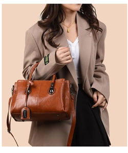 Detail of vintage oil wax leather tote with woven handle and adjustable strap on model