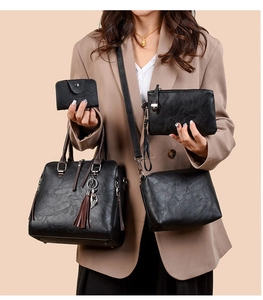 Detail of four-piece black leather handbag set with lychee texture and cat tassel charm