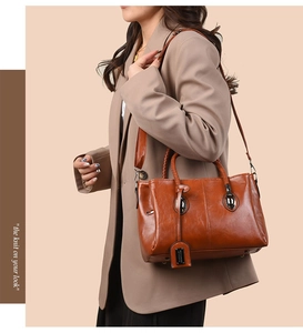 Detail of vintage oil wax leather tote with woven handles and silver metallic clasp