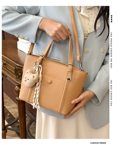 Détail de la texture cuir et du pendentif ours sur le sac seau de couleur camel