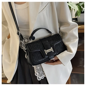 Dettaglio della borsa a tracolla in pelle nera goffrata con elegante chiusura H argento