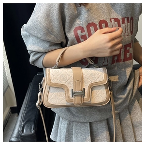 Vista dettagliata della borsa beige con motivo a rilievo GSTII e fibbia in metallo argento