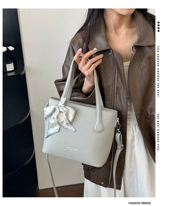 Détail d'un sac seau gris clair grainé avec foulard décoratif à motifs de coeurs