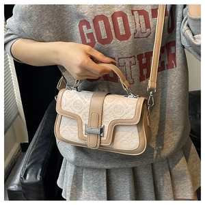 Dettaglio del logo GSTH e motivo a panda sulla borsa a tracolla beige goffrata