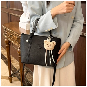 Détail du sac cabas noir grainé avec bandoulière réglable et breloque ours en peluche