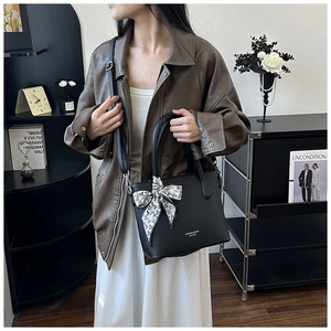 Sac seau chic en cuir grainé noir avec foulard imprimé et bandoulière sur mannequin
