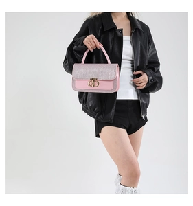 Detail of the pink leather handbag featuring a round gold buckle and sparkling textured flap