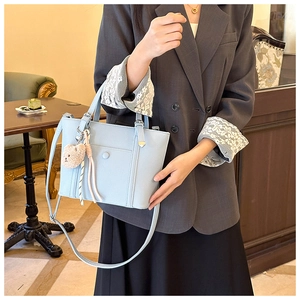 Sac seau bleu clair en cuir grainé avec bandoulière réglable et breloque ourson