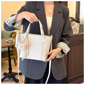 Détail du sac seau blanc en cuir grainé avec pendentif ours et foulard en soie chic