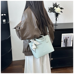 Détail du sac cabas vert menthe avec texture litchi et poignée foulard en soie