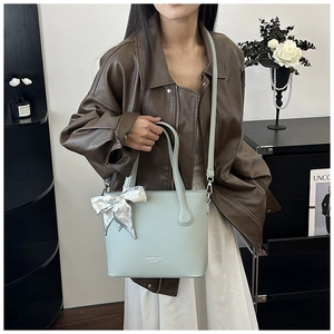 Détail du sac seau vert menthe avec texture cuir litchi et nœud en foulard de soie imprimé