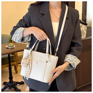 Détail du sac seau en cuir grainé blanc cassé avec pendentif ours et foulard en soie