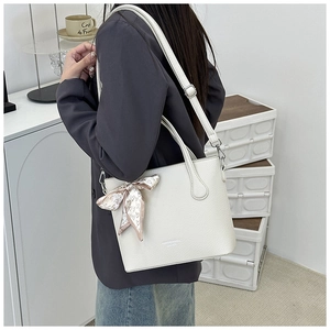 Détail du sac cabas en cuir crème avec foulard en soie à motif cœur sur l'anse