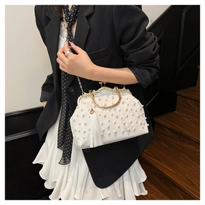 Macro detail of white pearl embroidery and luxury silk tassel on vintage evening bag