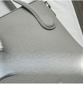 Détail du cuir grainé gris avec boucle métallique et foulard en soie décoratif sur le sac