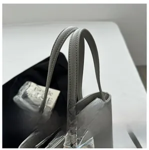 Détail du sac cabas en cuir gris texturé avec foulard et fermeture éclair argentée